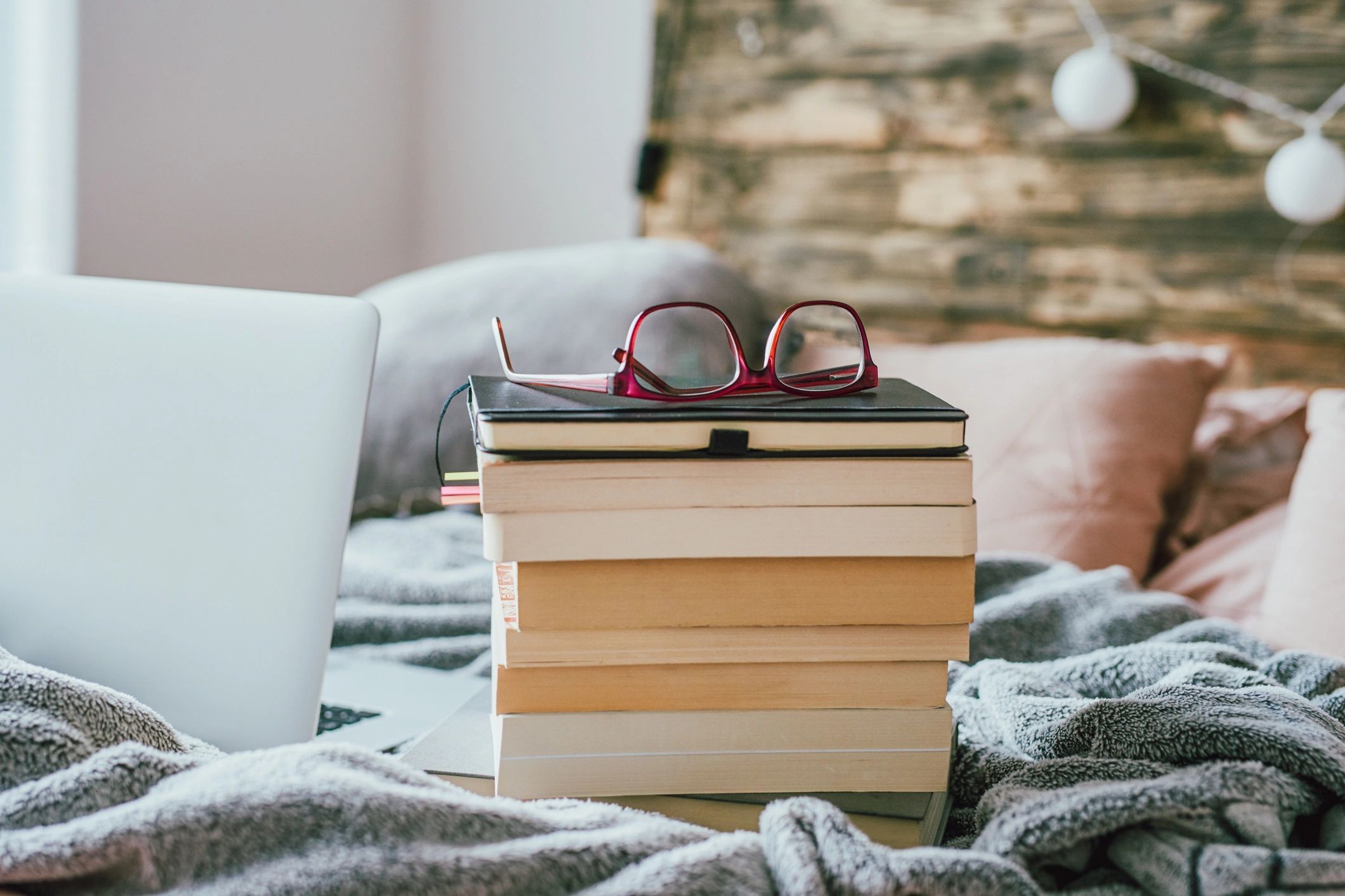 Stack of books with reading glasses on top