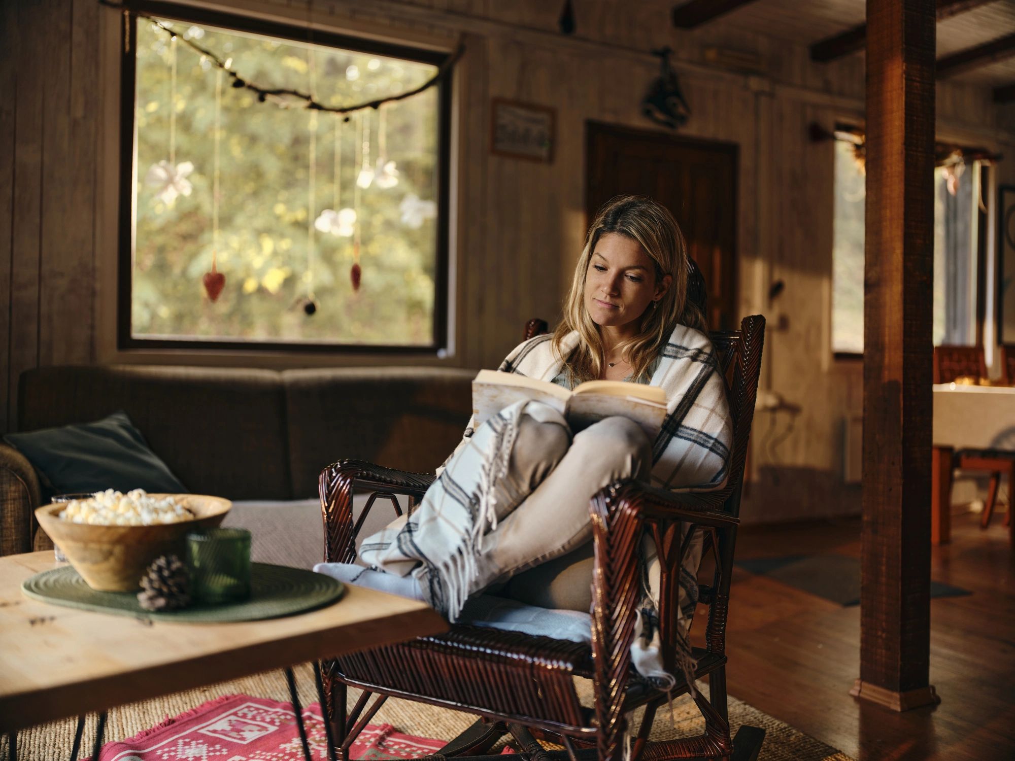 Person relaxing at home while reading a book.